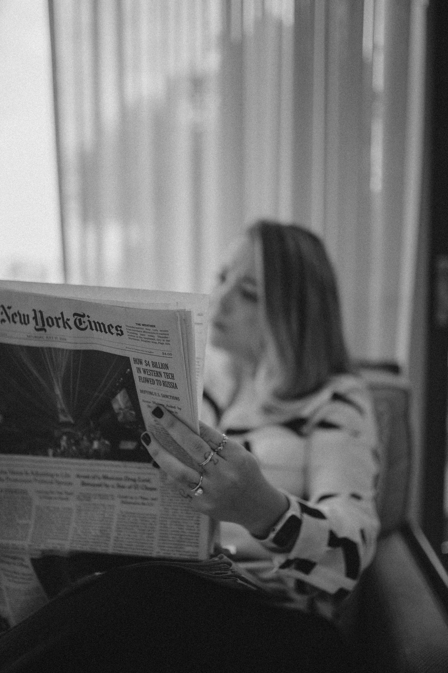 Sócia da The Minds lendo o jornal, acompanhando o mercado americano